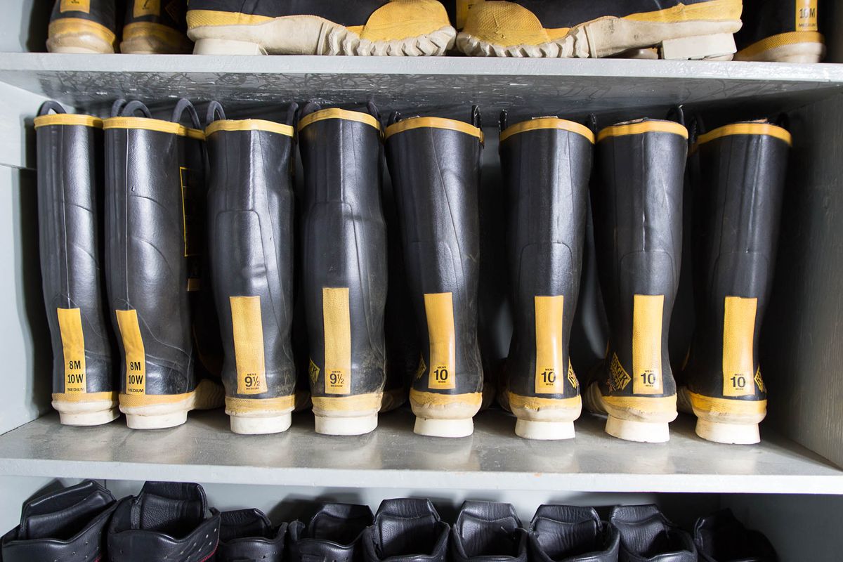 Rows of firefighting bunker boots and pants ready on shelves